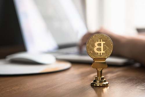 brass section gold-colored bitcoin on brown table musical instrument